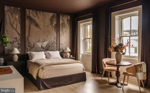 a bedroom with a large bed and a flat tv screen on dresser