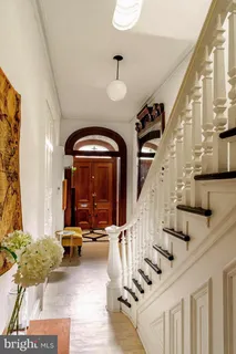 a view of staircase with lots of frames on wall and a large window