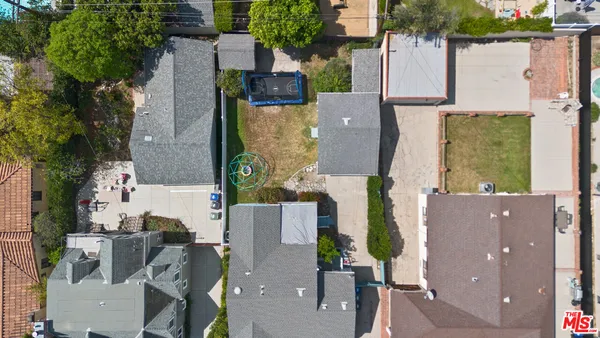 an aerial view of residential houses with outdoor space and parking