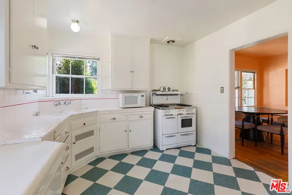 a kitchen with a stove a sink and a window