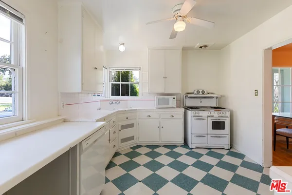 a kitchen with a stove a sink and a window