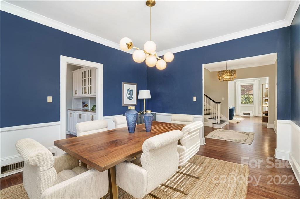 1520 Paddock Circle Charlotte, NC 28209 - Photo 11 of 39 a living room with couches a chandelier and a dining table with wooden floor