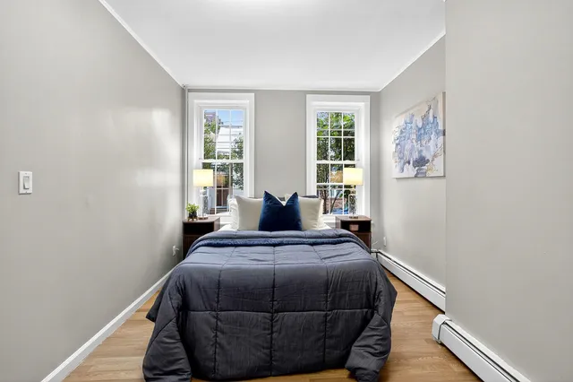 a bedroom with a bed and wooden floor