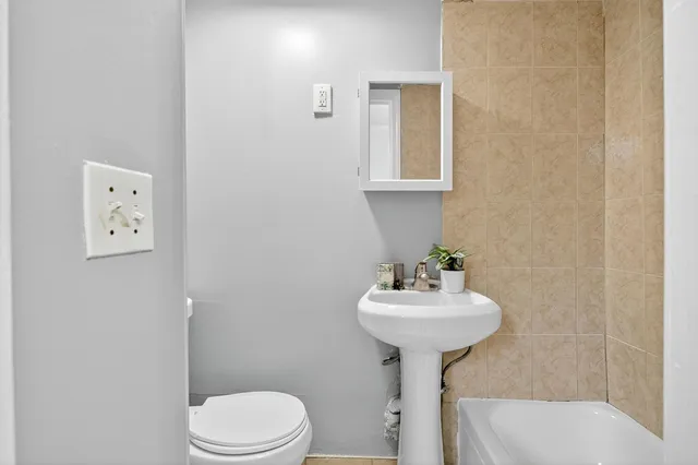a bathroom with a sink toilet and a mirror