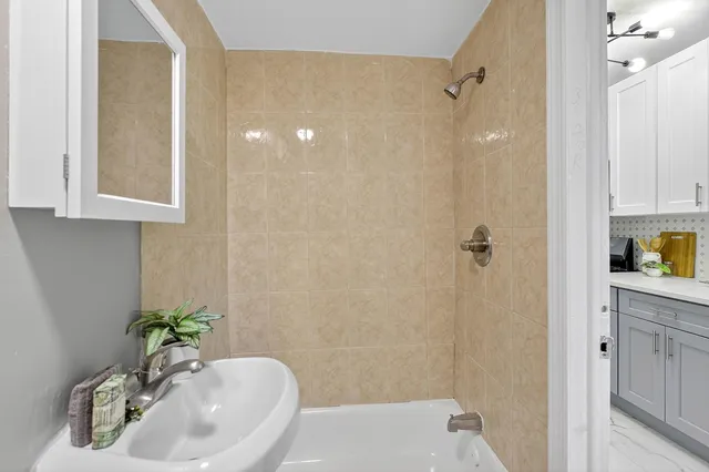 a bath room with a sink a mirror and a shower