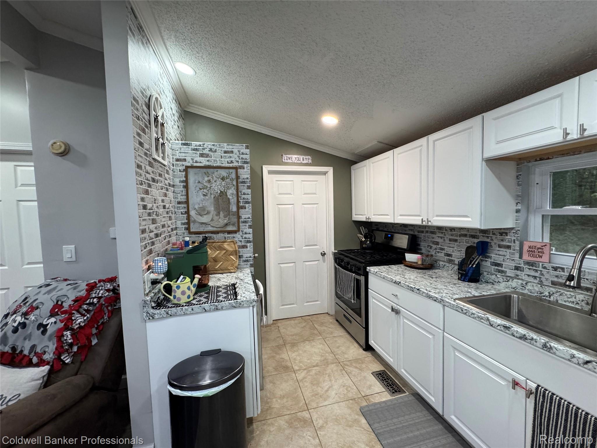5323 English Road Clifford, MI 48727 - Photo 12 of 46 Kitchen featuring white cabinetry, stainless steel sink, tile backsplash, and granite-style countertops