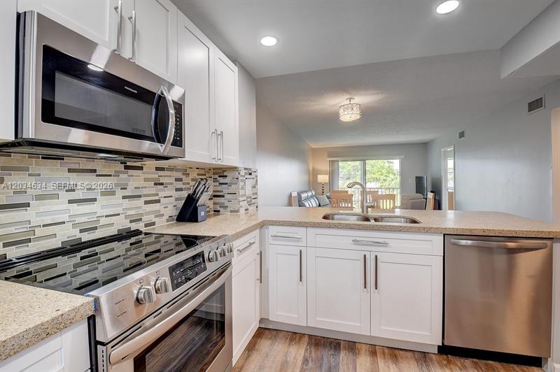9880 Marina Boulevard, Unit 1516 Boca Raton, FL 33428 - Photo 3 of 32 a kitchen with a stove and a microwave