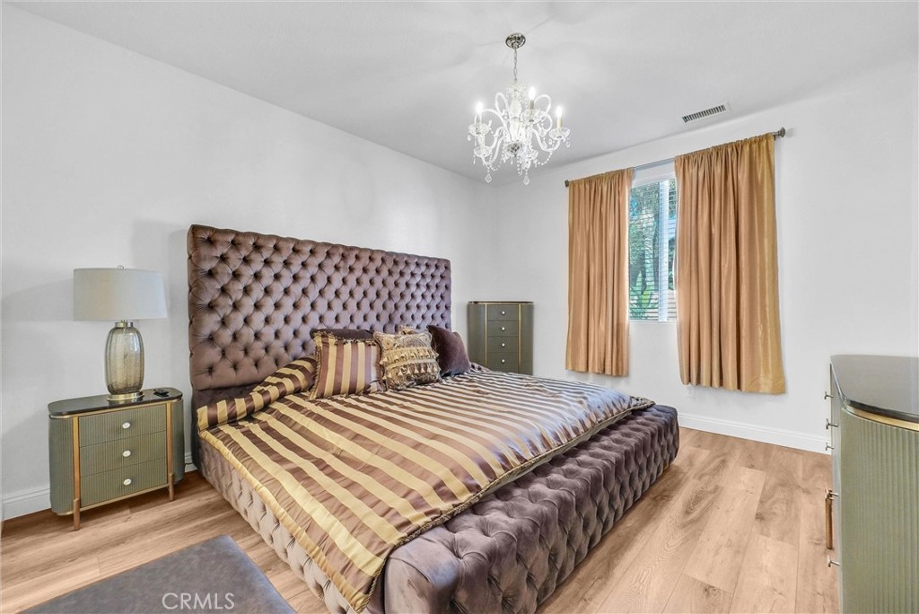 11499 Bridgeway Drive Riverside, CA 92505 - Photo 25 of 70 a bedroom with a large bed and a chandelier