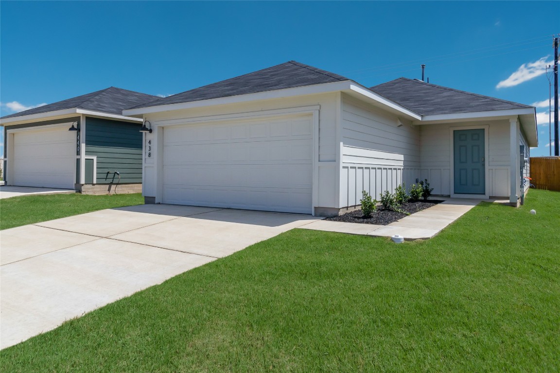 a view of a house with a yard and garage