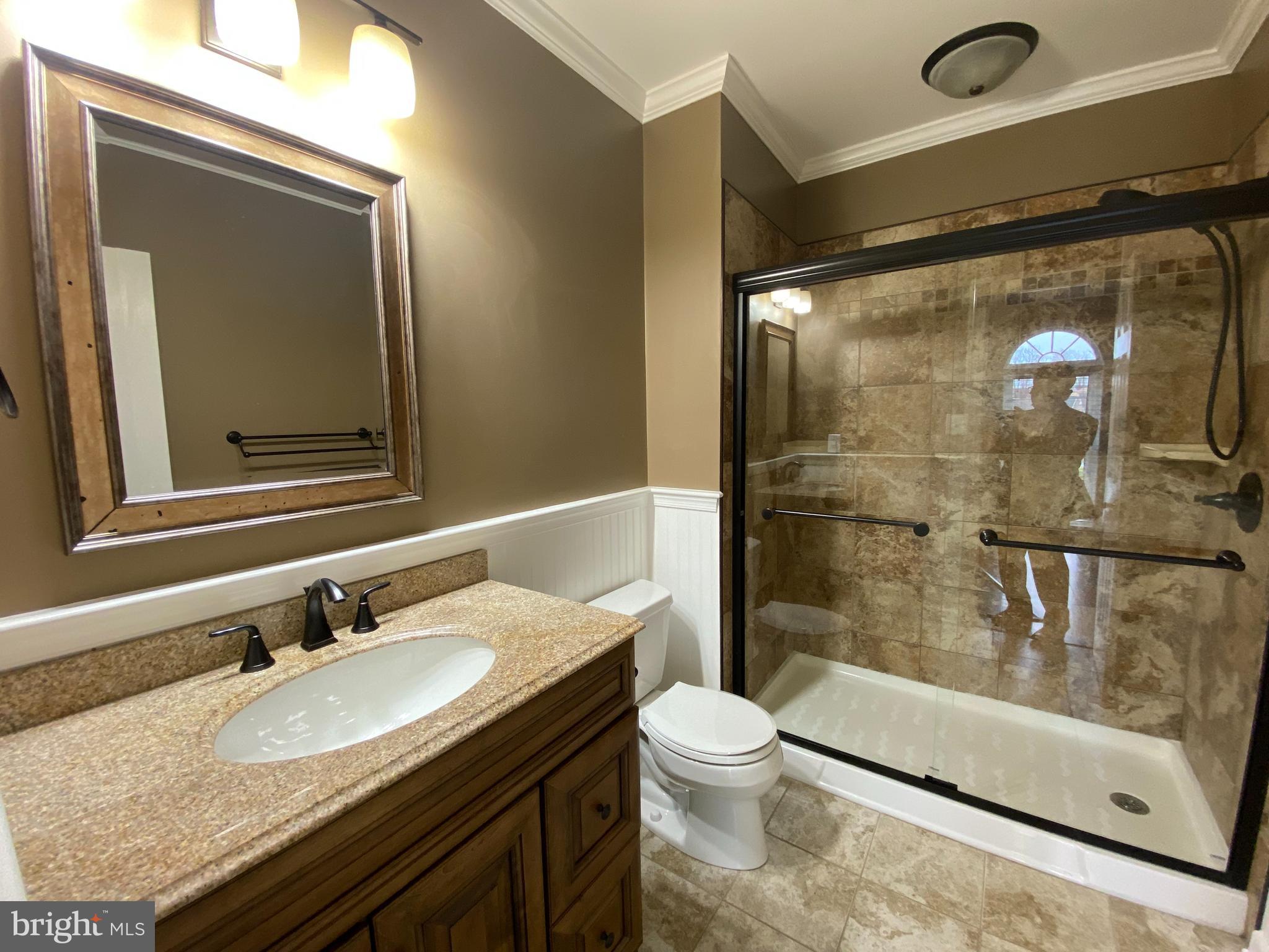 4 Victoria Square Frederick, MD 21702 - Photo 25 of 38 a bathroom with a granite countertop sink a mirror and a shower