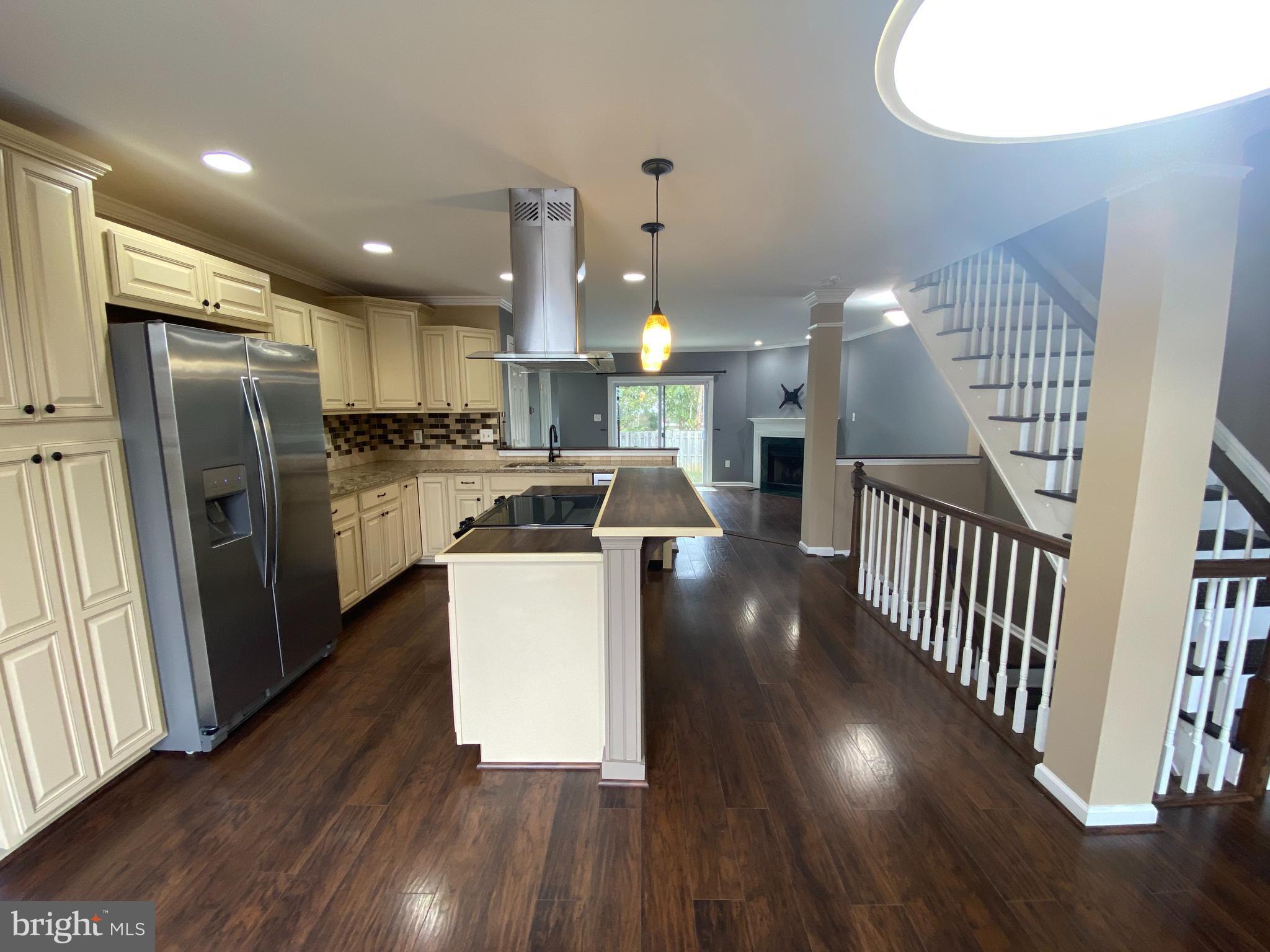 4 Victoria Square Frederick, MD 21702 - Photo 3 of 38 an open kitchen with wooden floor and stainless steel appliances