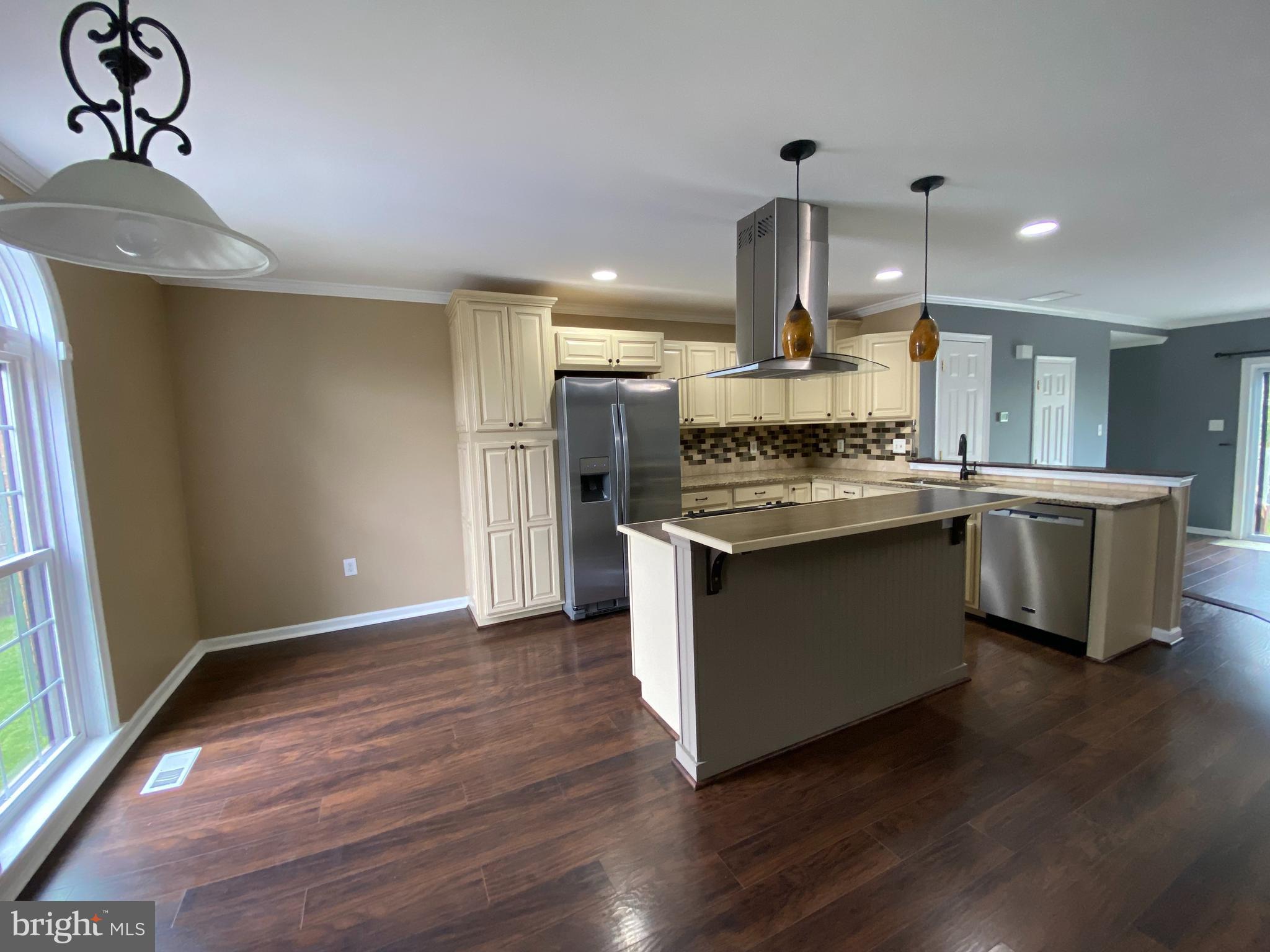 4 Victoria Square Frederick, MD 21702 - Photo 10 of 38 a kitchen with stainless steel appliances granite countertop wooden floors and white walls