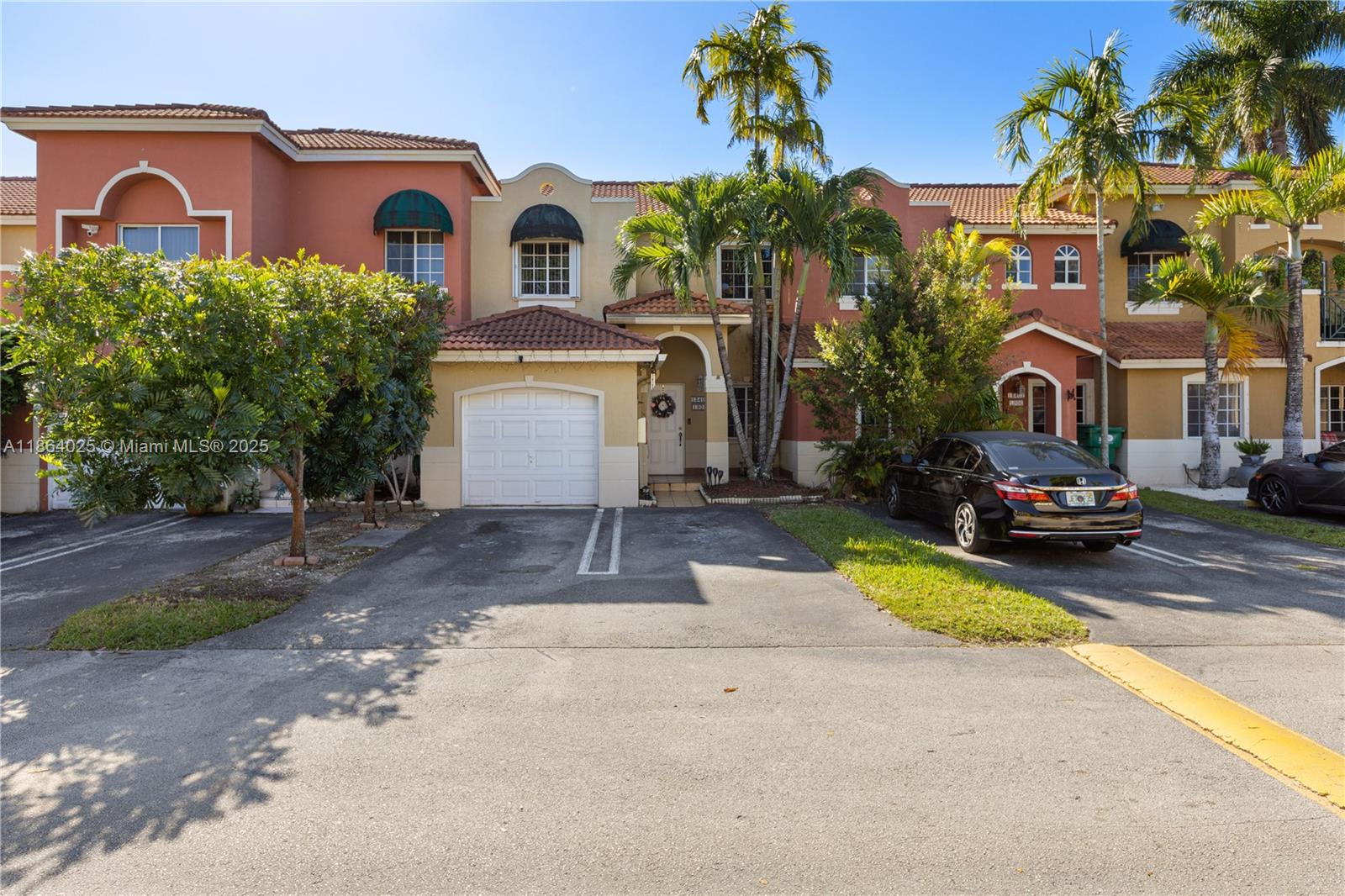 a front view of a house with a garden and parking