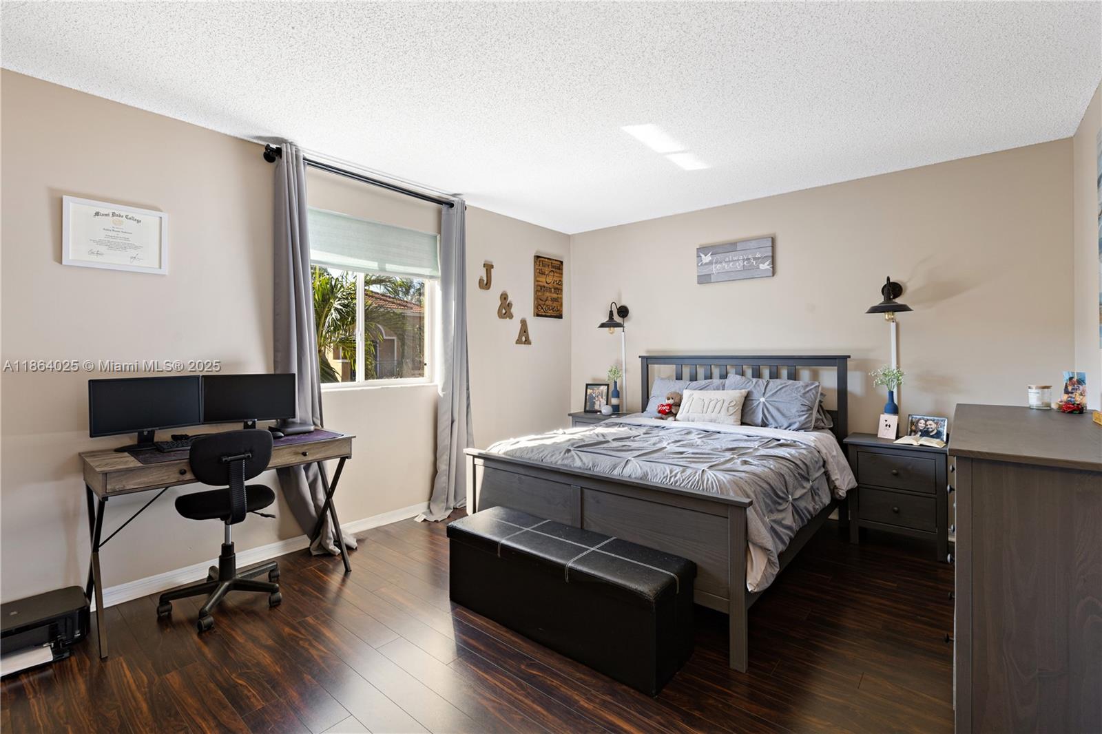 13402 Southwest 153rd Street, Unit 1905 Miami, FL 33177 - Photo 16 of 21 a bedroom with a bed a desk and chair with wooden floor