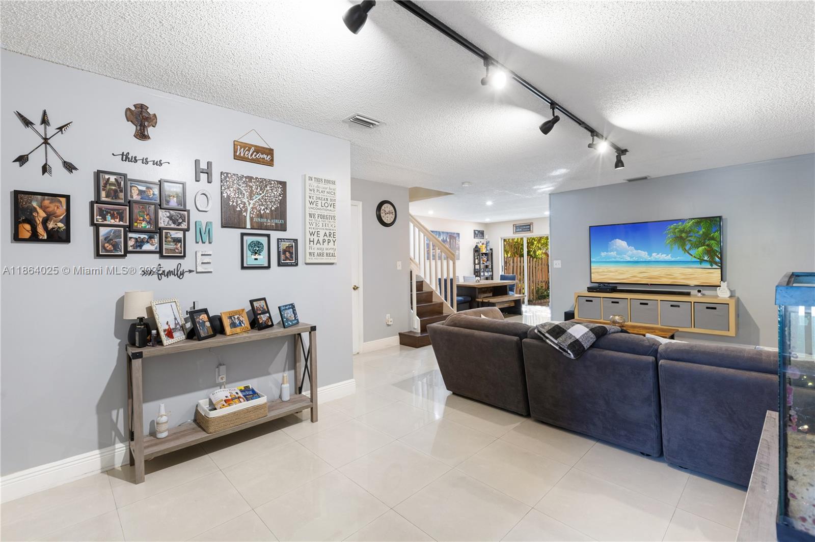 13402 Southwest 153rd Street, Unit 1905 Miami, FL 33177 - Photo 2 of 21 a living room with furniture and a flat screen tv