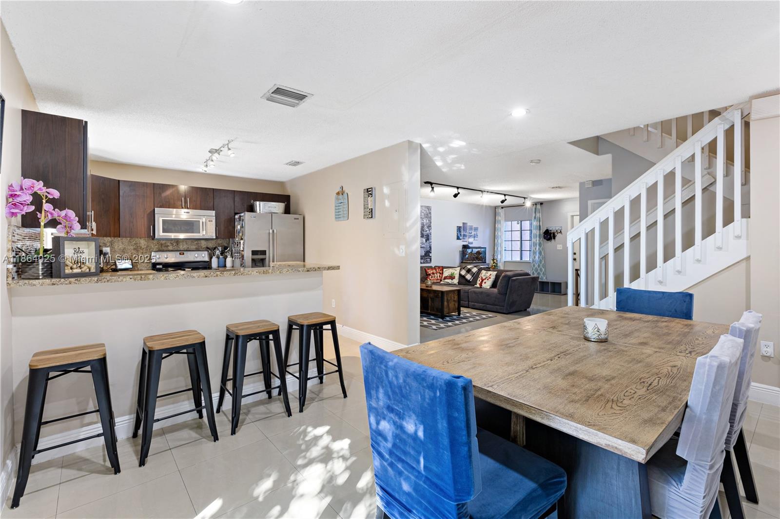 13402 Southwest 153rd Street, Unit 1905 Miami, FL 33177 - Photo 5 of 21 a kitchen with sink a refrigerator and chairs