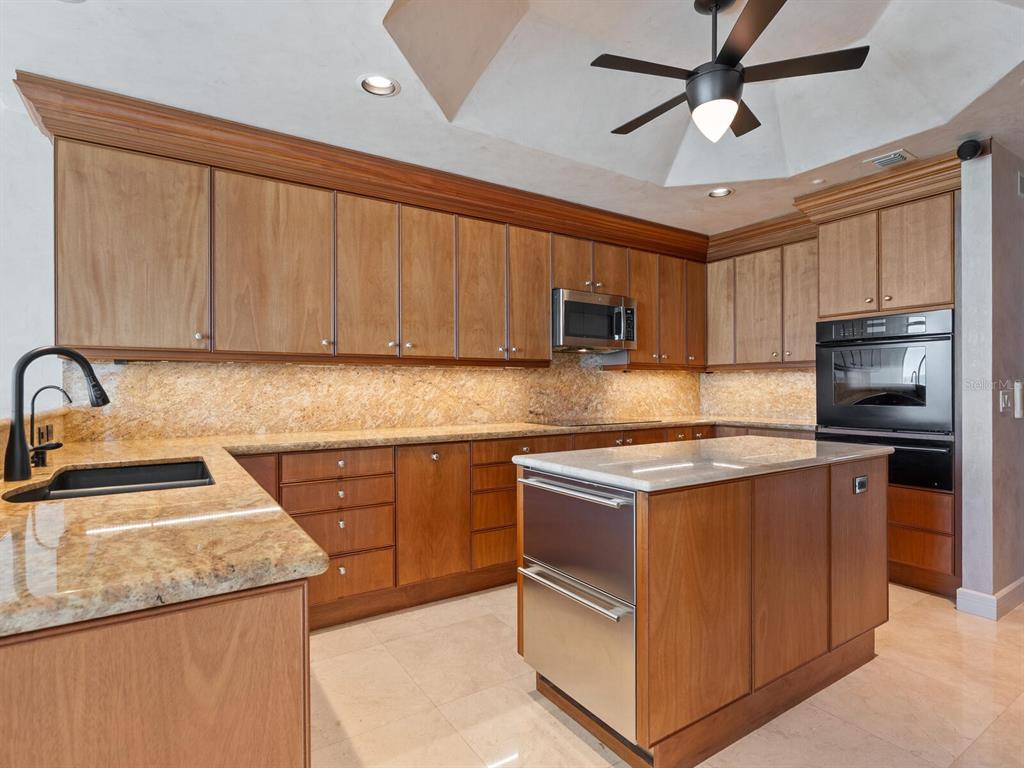 655 Longboat Club Road, Unit 16B Longboat Key, FL 34228 - Photo 14 of 50 a kitchen with stainless steel appliances granite countertop a sink stove microwave and cabinets