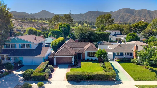 a aerial view of a house with a big yard and large trees