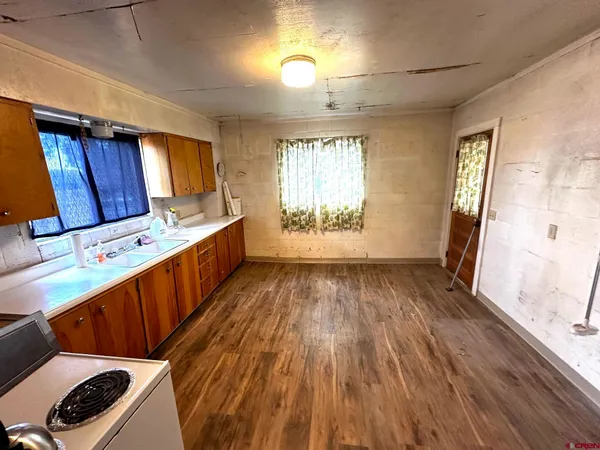 a kitchen with wooden floors and sink