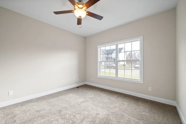 an empty room with a window and a fan