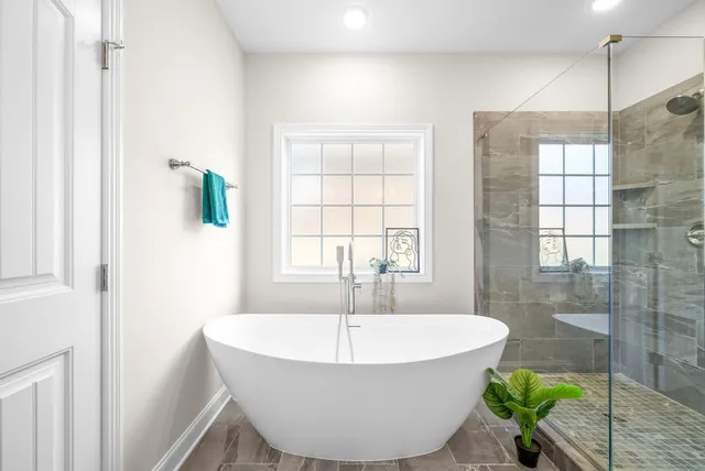 a white bath tub sitting in a bathroom next to a window