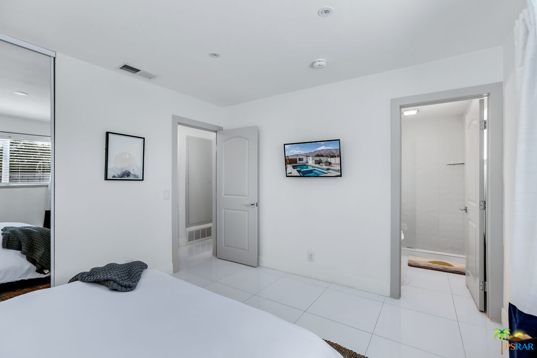 2312 North Blando Road Palm Springs, CA 92262 - Photo 19 of 27 a bedroom with a bed and a view of bathroom