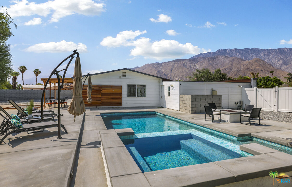 2312 North Blando Road Palm Springs, CA 92262 - Photo 22 of 27 a view of a patio with couches table and chairs with wooden floor and fence