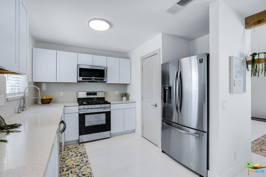 2312 North Blando Road Palm Springs, CA 92262 - Photo 10 of 27 a kitchen with stainless steel appliances a refrigerator sink and microwave