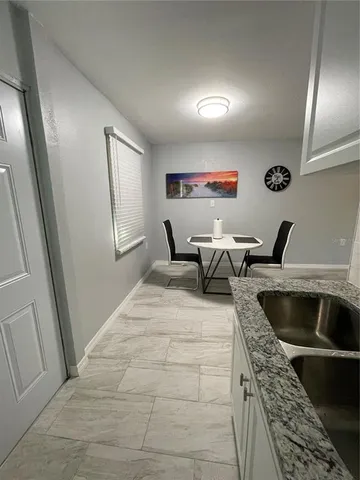 a living room with chairs and a rug