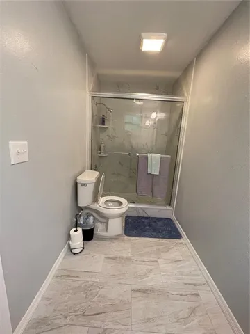 a bathroom with a toilet and a shower