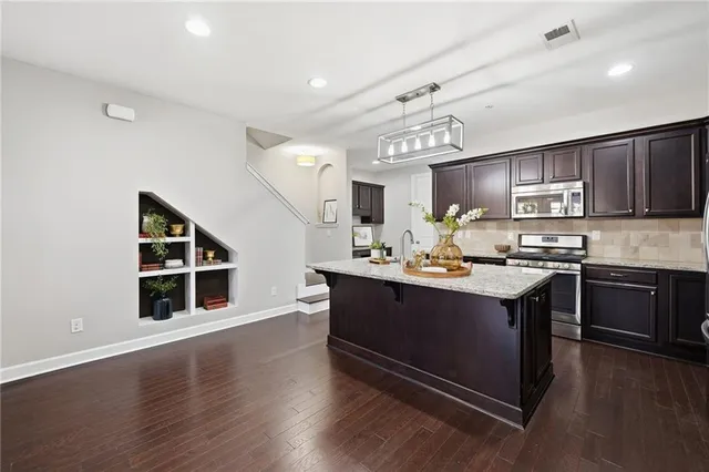 a kitchen with stainless steel appliances granite countertop a sink stove and cabinets