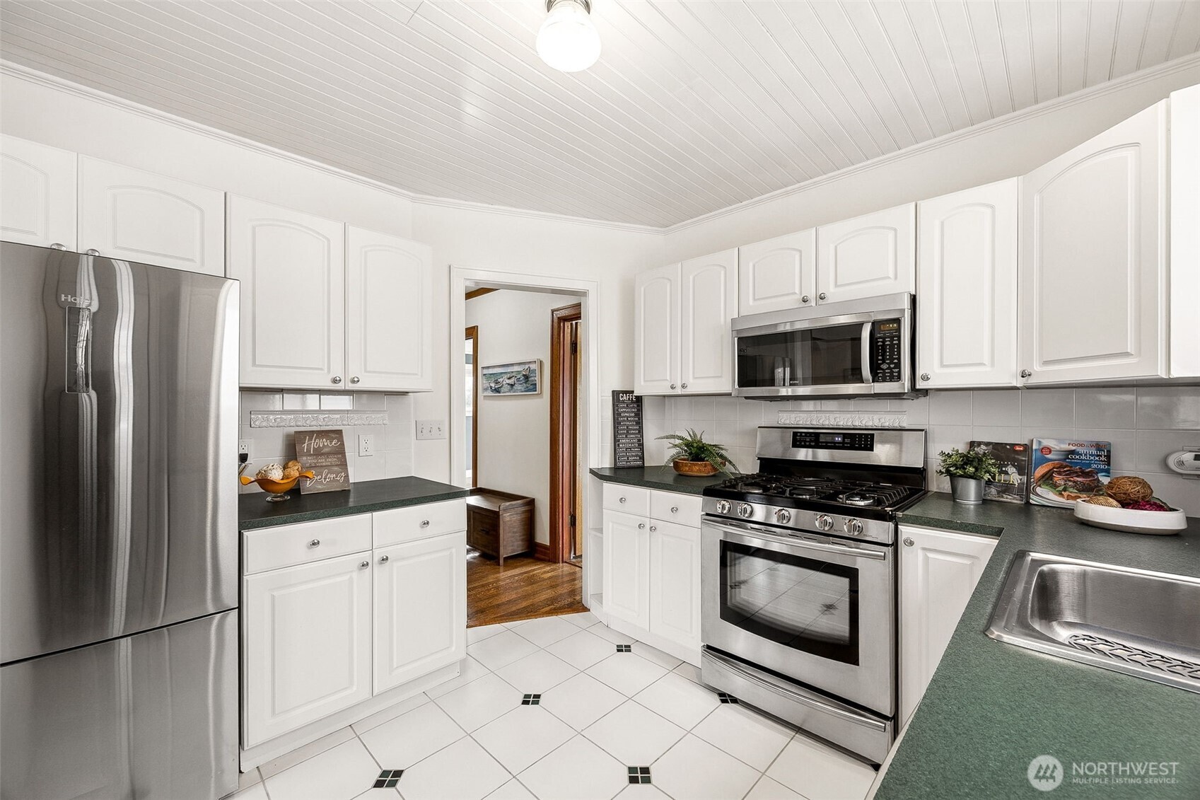 2819 Northwest 68th Street Seattle, WA 98117 - Photo 10 of 39 a kitchen with white cabinets and stainless steel appliances