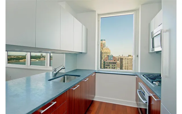 a kitchen with a sink a counter top space and cabinets