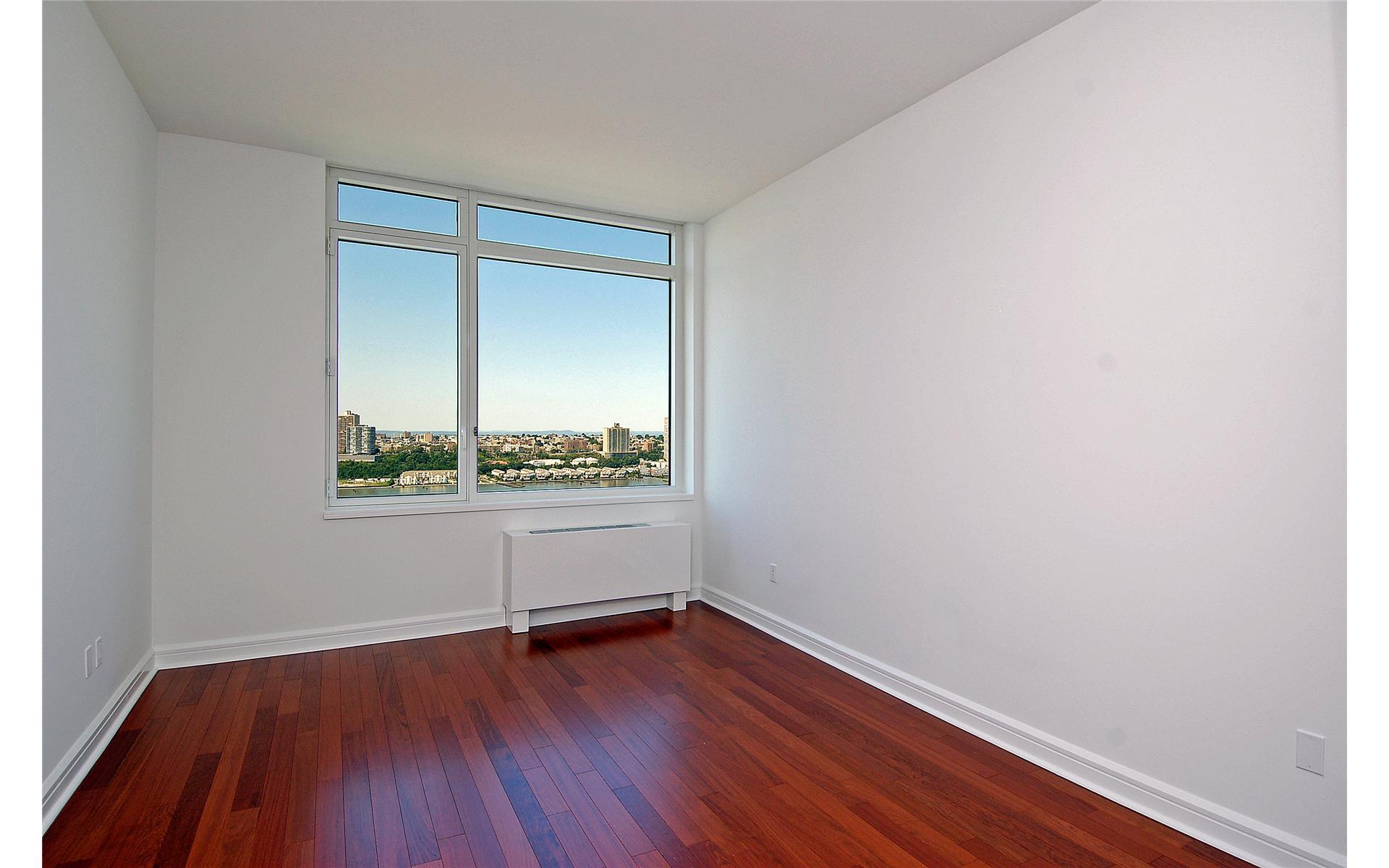 100 Riverside Boulevard, Unit 31B Manhattan, NY 10069 - Photo 4 of 17 a view of an empty room with wooden floor and a window