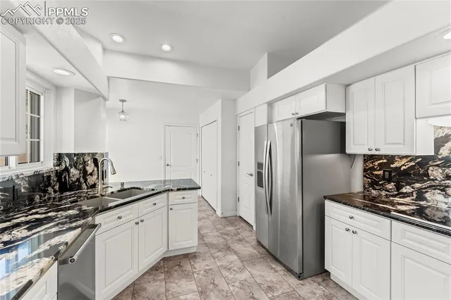 a kitchen with white cabinets and sink