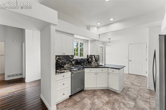 a kitchen with stainless steel appliances a sink a stove a microwave a counter top space and cabinets