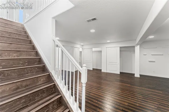 a view of a hallway with wooden floor and entryway