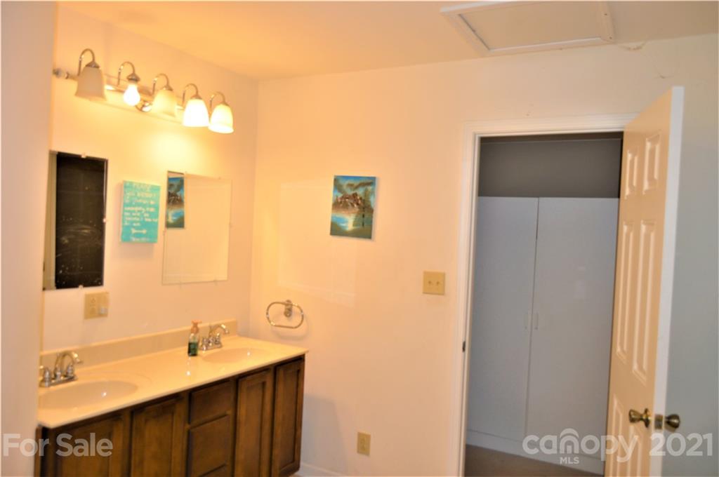 10835 Cool Springs Road Woodleaf, NC 27054 - Photo 23 of 35 a bathroom with a double vanity sink and mirror