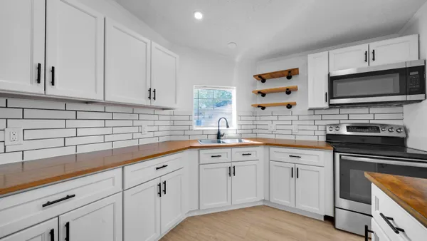 a kitchen with cabinets stainless steel appliances and a sink