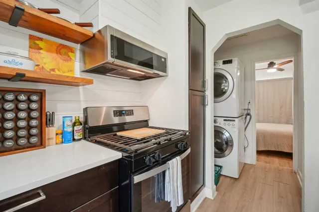a kitchen with stainless steel appliances granite countertop a stove and a wooden floors