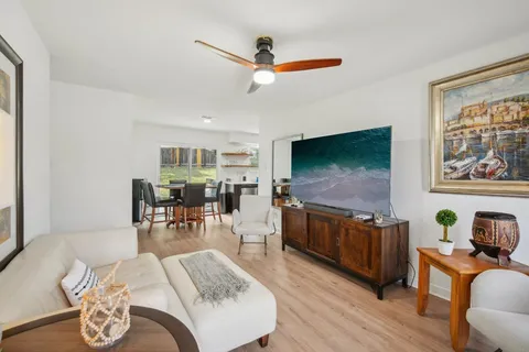 a living room with furniture flat screen tv and wooden floor