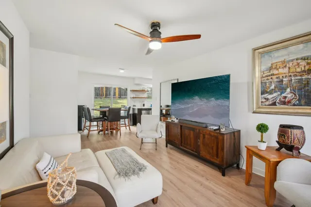 a living room with furniture flat screen tv and wooden floor