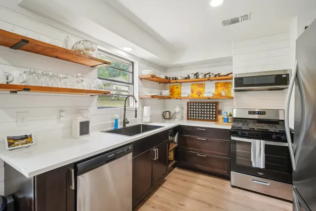 a kitchen with stainless steel appliances a sink stove and cabinets