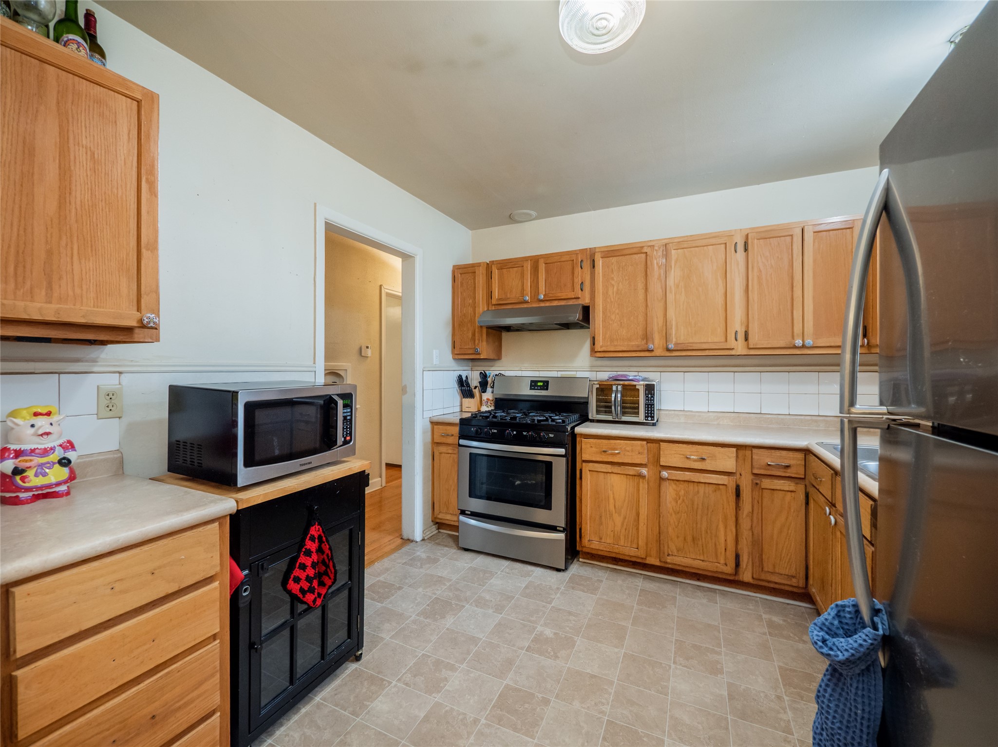 1910 South 13th Street Temple, TX 76504 - Photo 7 of 35 a kitchen with stainless steel appliances granite countertop a stove top oven a sink dishwasher and a microwave oven on the blue kitchen countertops