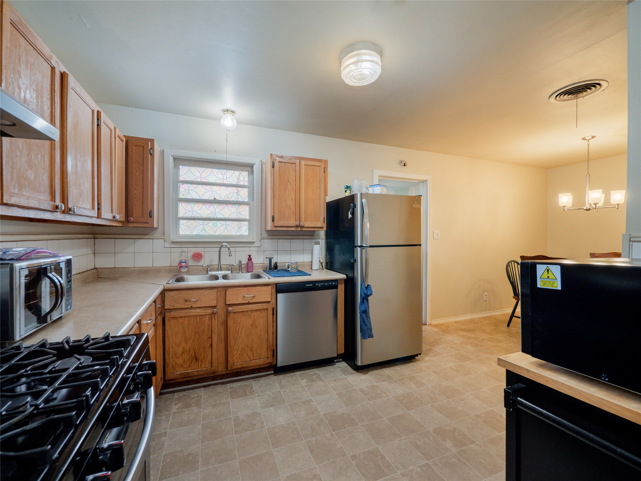 1910 South 13th Street Temple, TX 76504 - Photo 8 of 35 a kitchen with a refrigerator and a stove top oven
