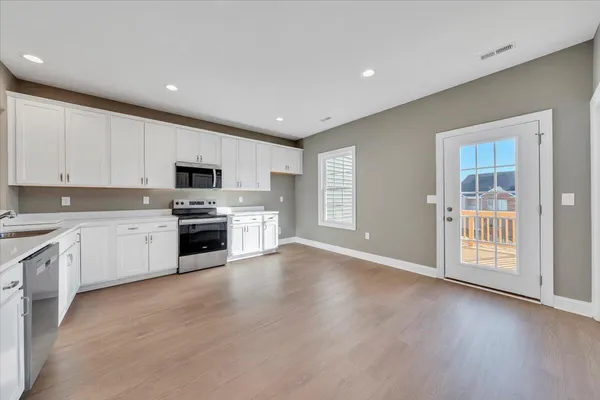a kitchen with granite countertop white cabinets and white appliances