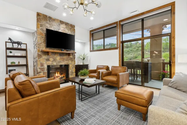 a kitchen with stainless steel appliances a sink a stove a refrigerator cabinets and a dining table