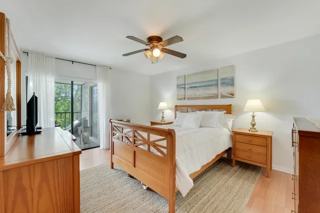 a bedroom with a bed and a flat tv screen on dresser