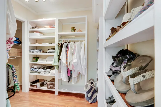a view of walk in closet with clothes and shoes
