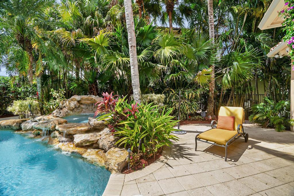 17542 Grand Este Way Boca Raton, FL 33496 - Photo 40 of 45 a garden with a bench and some potted plants
